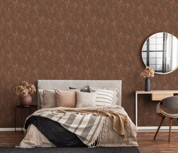 Erismann Fashion For Walls 4 10375-48 wallpaper bedroom feature wall behind an upholstered bed with layered pillows and striped throw, round mirror above a slim console, side table and chair with dried flowers, calm cozy mood.