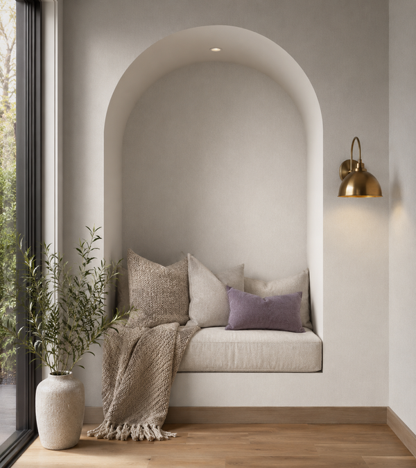 Erismann Fashion For Walls 4 10376-26 wallpaper lounge feature wall with arched alcove bench, layered cushions and throw, brass sconce, floor plant by large window, serene mood.