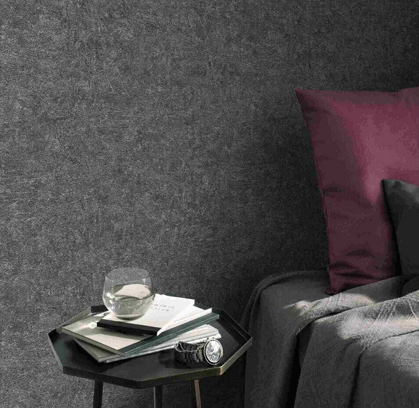 Erismann Fashion For Walls 4 10377-10 wallpaper modern lounge feature wall, small side table with glass and books beside a sofa with plum cushion, calm minimalist mood.