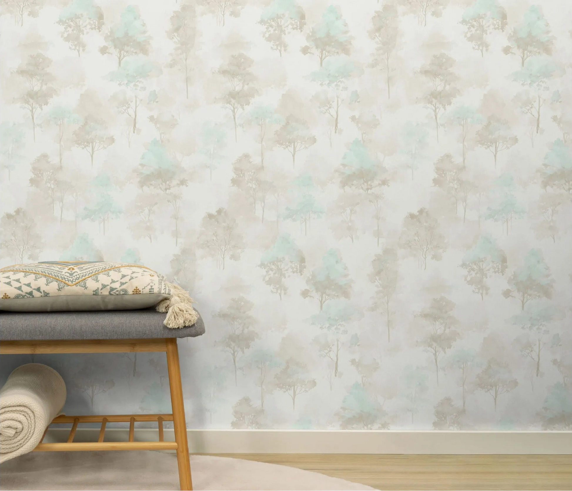 Erismann Forest Dreams 10557-02 wallpaper Full-height application on a straight wall behind a bench; baseboard visible along bottom edge behind wooden bench with grey cushion beside patterned decorative pillow with tassels near rolled blanket on bench shelf.
