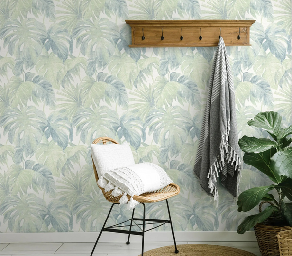 Erismann Forest Dreams 10558-07 wallpaper on an accent wall behind a wicker chair, wall hook rack, hanging throw, and potted plant.