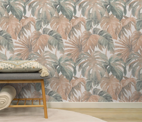 Erismann Forest Dreams 10558-11 wallpaper with muted tropical leaves behind a bench with a patterned cushion and rolled throw.