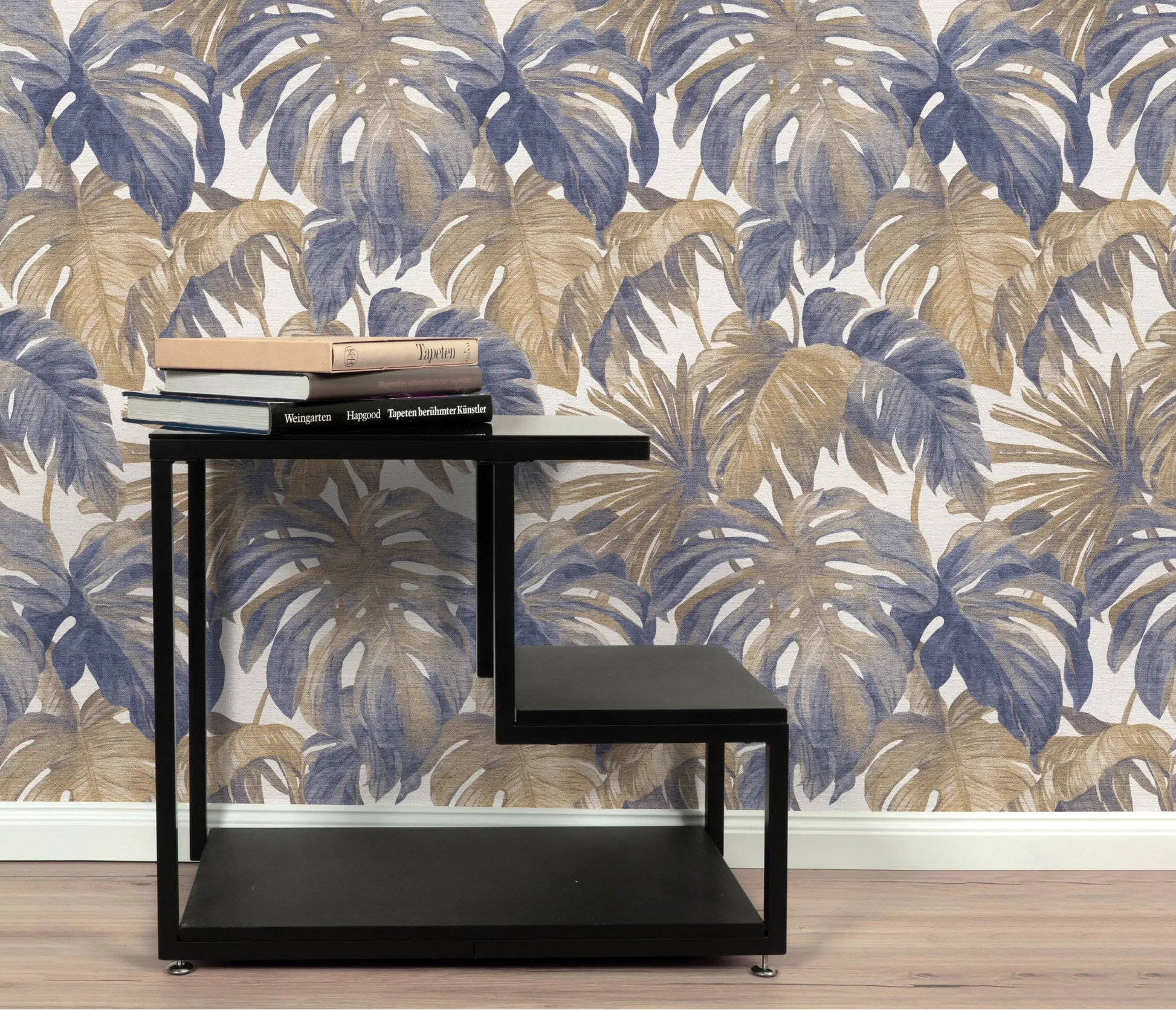 Erismann Forest Dreams 10558-44 wallpaper on a wall behind a black shelving unit topped with stacked books.