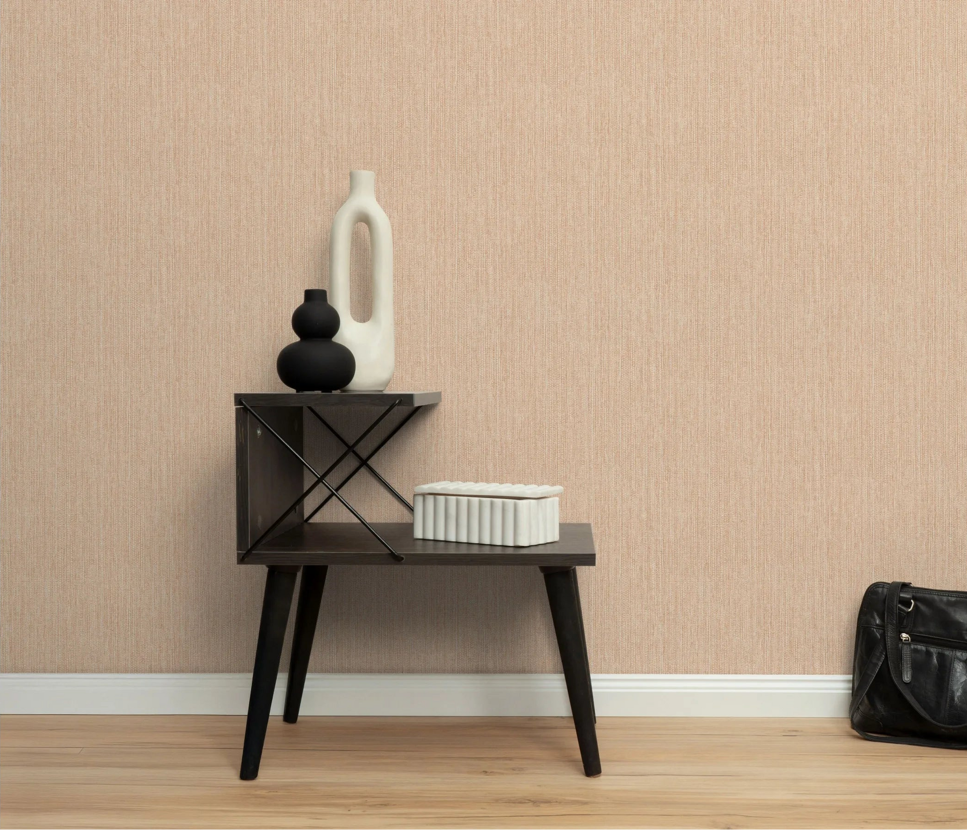 Erismann Forest Dreams 10559-04 wallpaper on a textured beige wall behind a dark side table with vases and a bag.