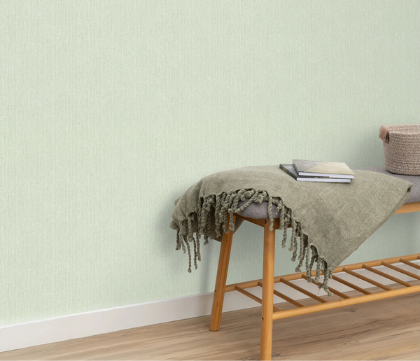 Erismann Forest Dreams 10559-07 wallpaper on the wall behind a wooden bench with fringed throw, books, and woven basket.