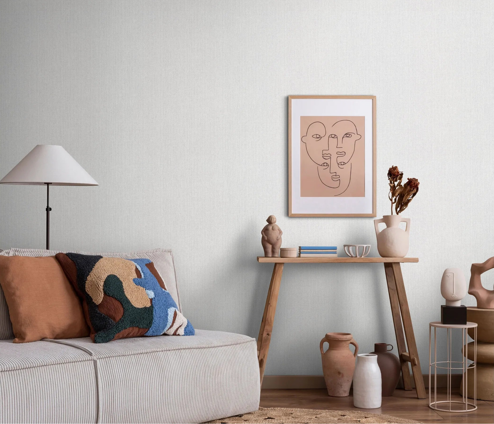 Erismann Forest Dreams 10559-31 wallpaper on a pale textured living room wall behind a sofa, console table, framed art, and vases.