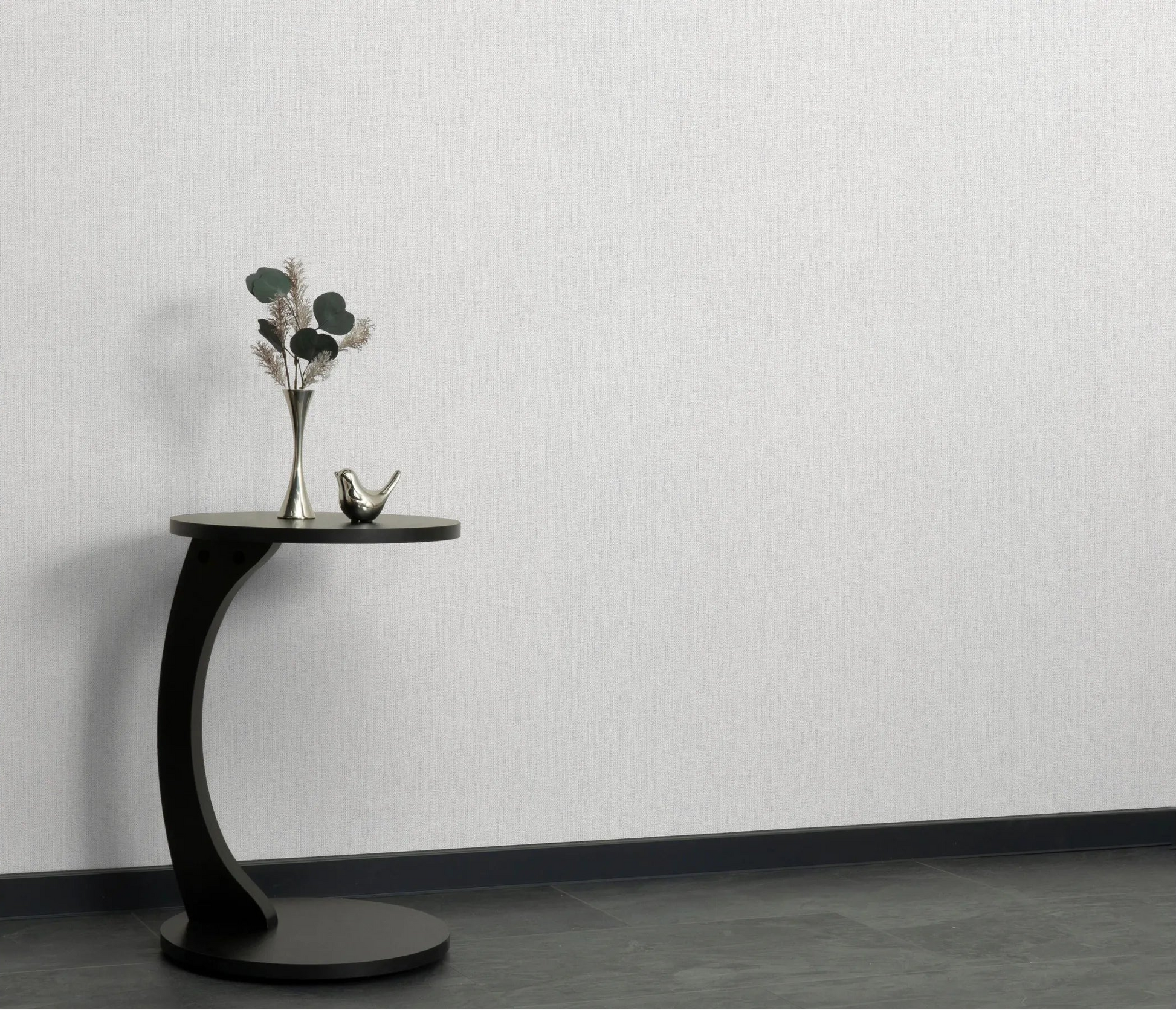 Erismann Forest Dreams 10559-31 wallpaper on a pale textured wall behind a black side table with vase and bird ornament.