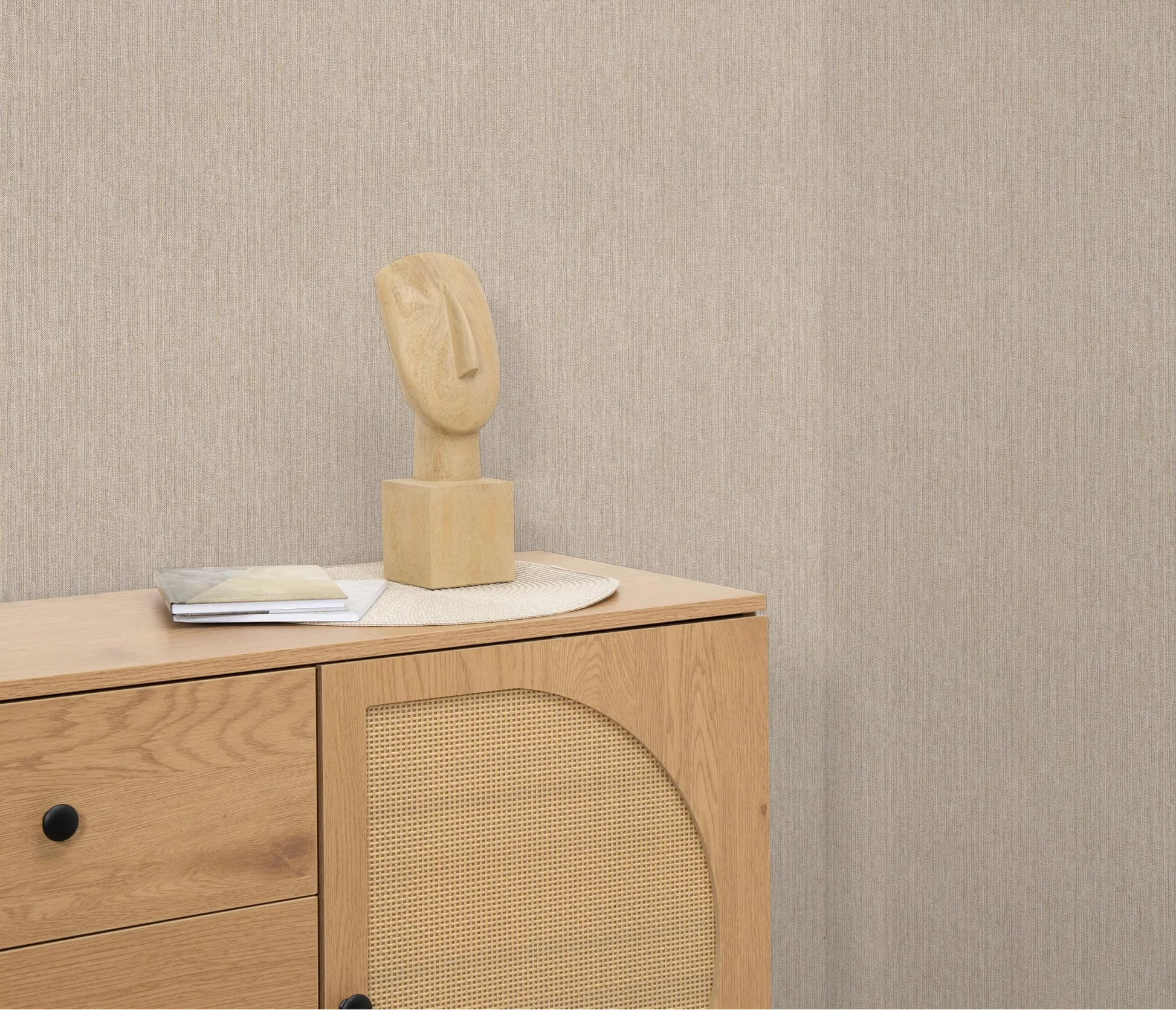 Erismann Forest Dreams 10559-32 wallpaper on the wall behind a wooden chest of drawers with sculpture and stacked books.