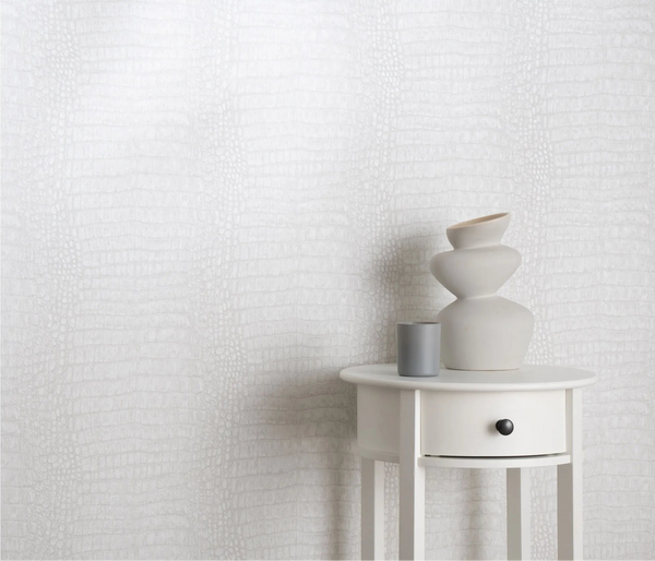 Erismann Forest Dreams 10560-10 wallpaper with subtle textured pattern behind a white side table with sculptural vase and candle.