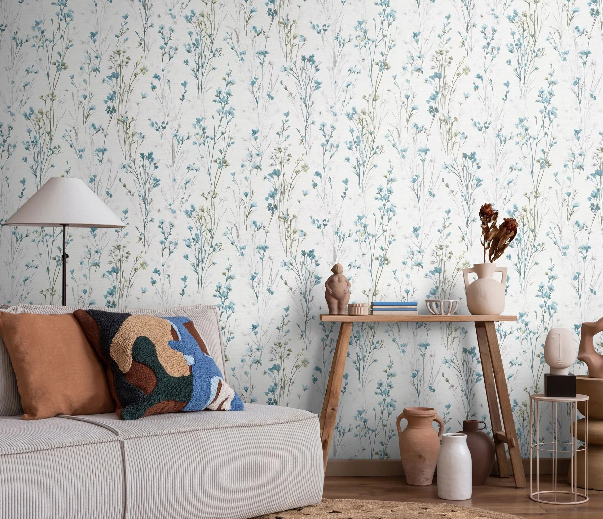 Erismann Forest Dreams 10561-18 wallpaper with delicate blue wildflower stems behind a sofa, floor lamp, and wooden console table.