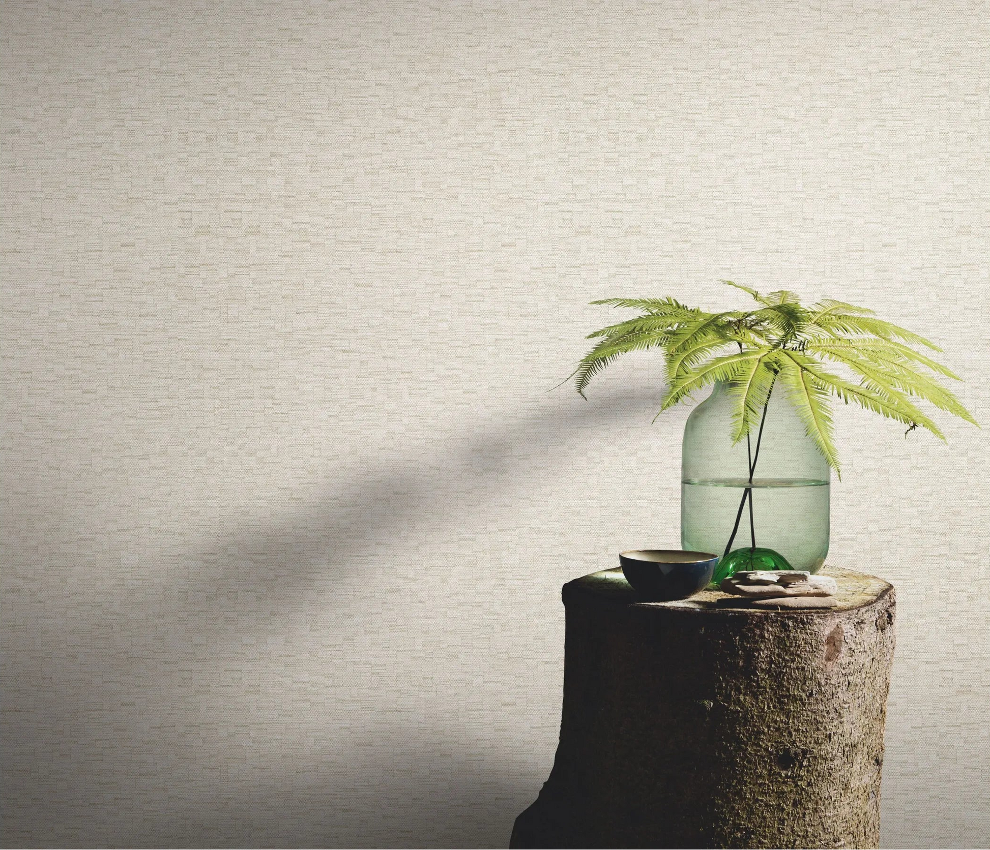Erismann Forest Dreams 10562-02 wallpaper on a textured wall behind a tree-stump table with glass vase and fern stems.