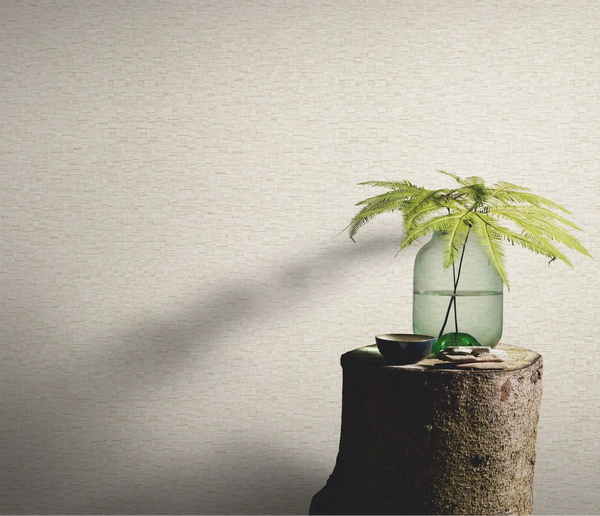 Erismann Forest Dreams 10562-02 wallpaper on a textured wall behind a tree-stump table with glass vase and fern stems.