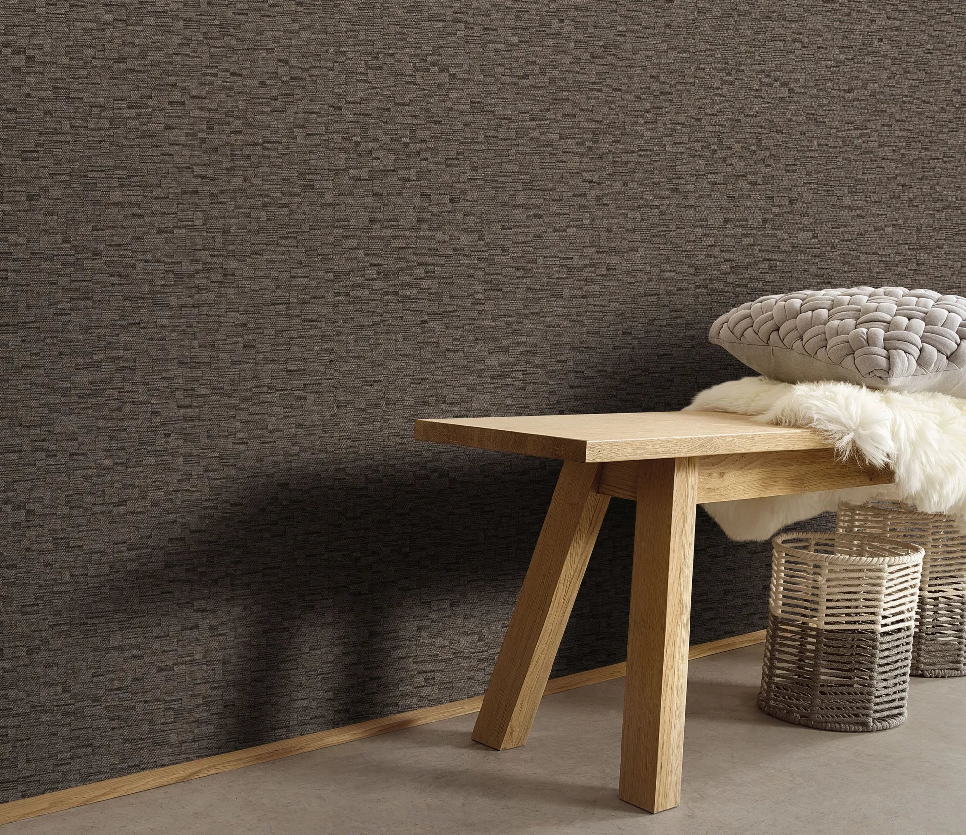 Erismann Forest Dreams 10562-11 wallpaper on the wall behind a wooden bench with tufted cushion, faux fur throw, and woven baskets.