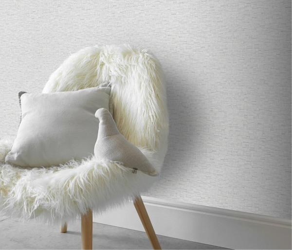 Erismann Forest Dreams 10562-31 wallpaper on the wall behind a faux fur chair with neutral cushions.