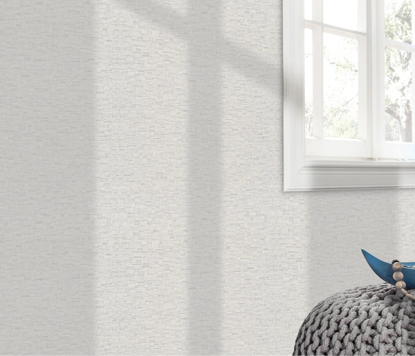 Erismann Forest Dreams 10562-31 wallpaper on a pale textured wall beside a white framed window and knitted pouf.