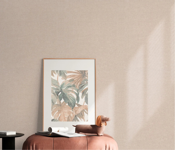 Erismann Forest Dreams 10563-05 wallpaper on a textured beige wall behind a framed botanical print, ottoman, books, and dog figurine.