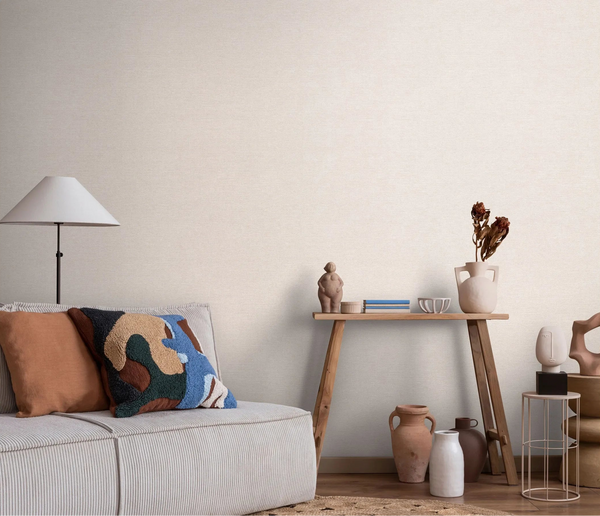 Erismann Forest Dreams 10563-14 wallpaper on a softly textured wall behind a sofa, cushions, lamp, and decorative console table.