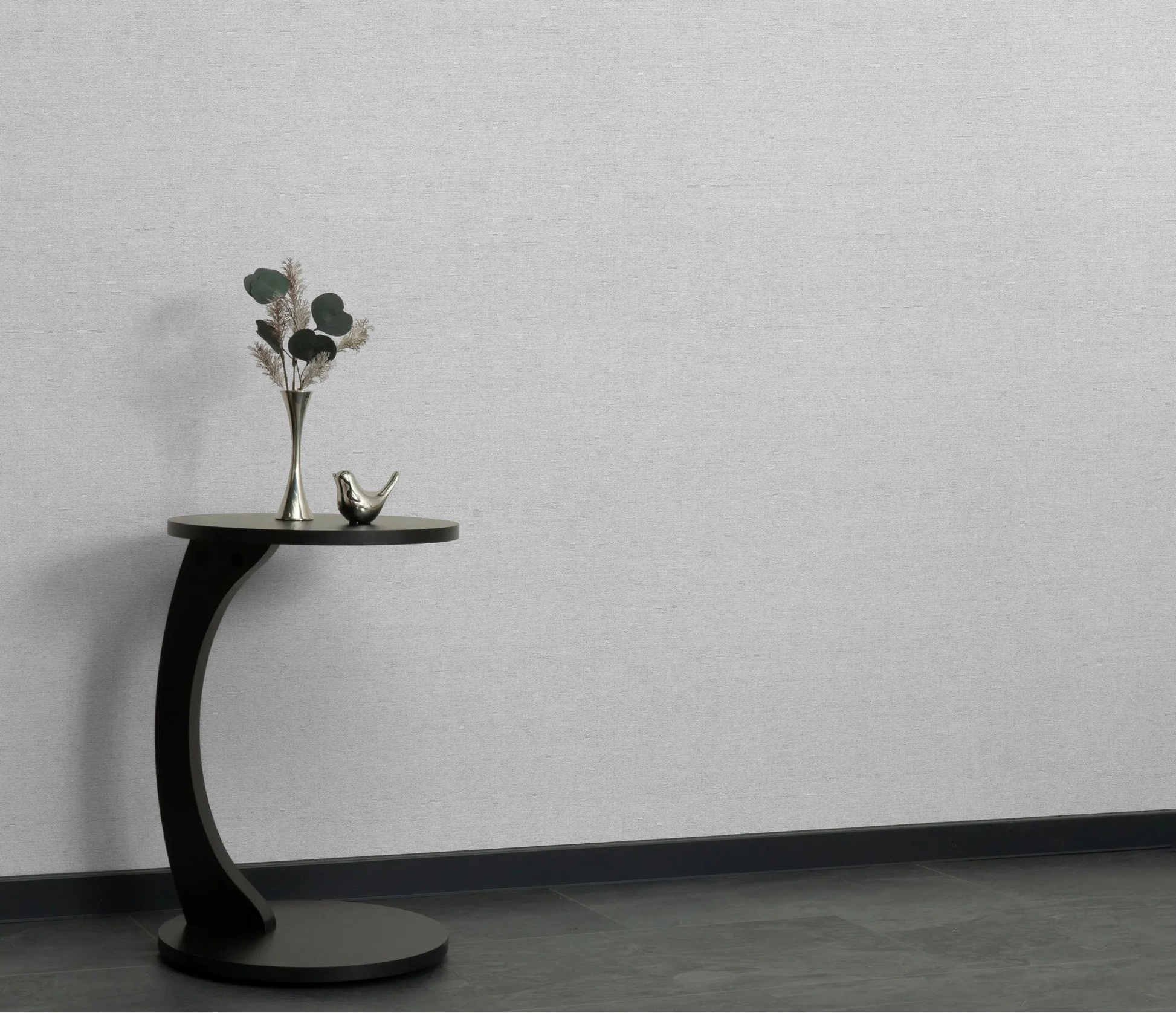 Erismann Forest Dreams 10563-31 wallpaper on a textured grey wall behind a black side table with vase and bird figurine.