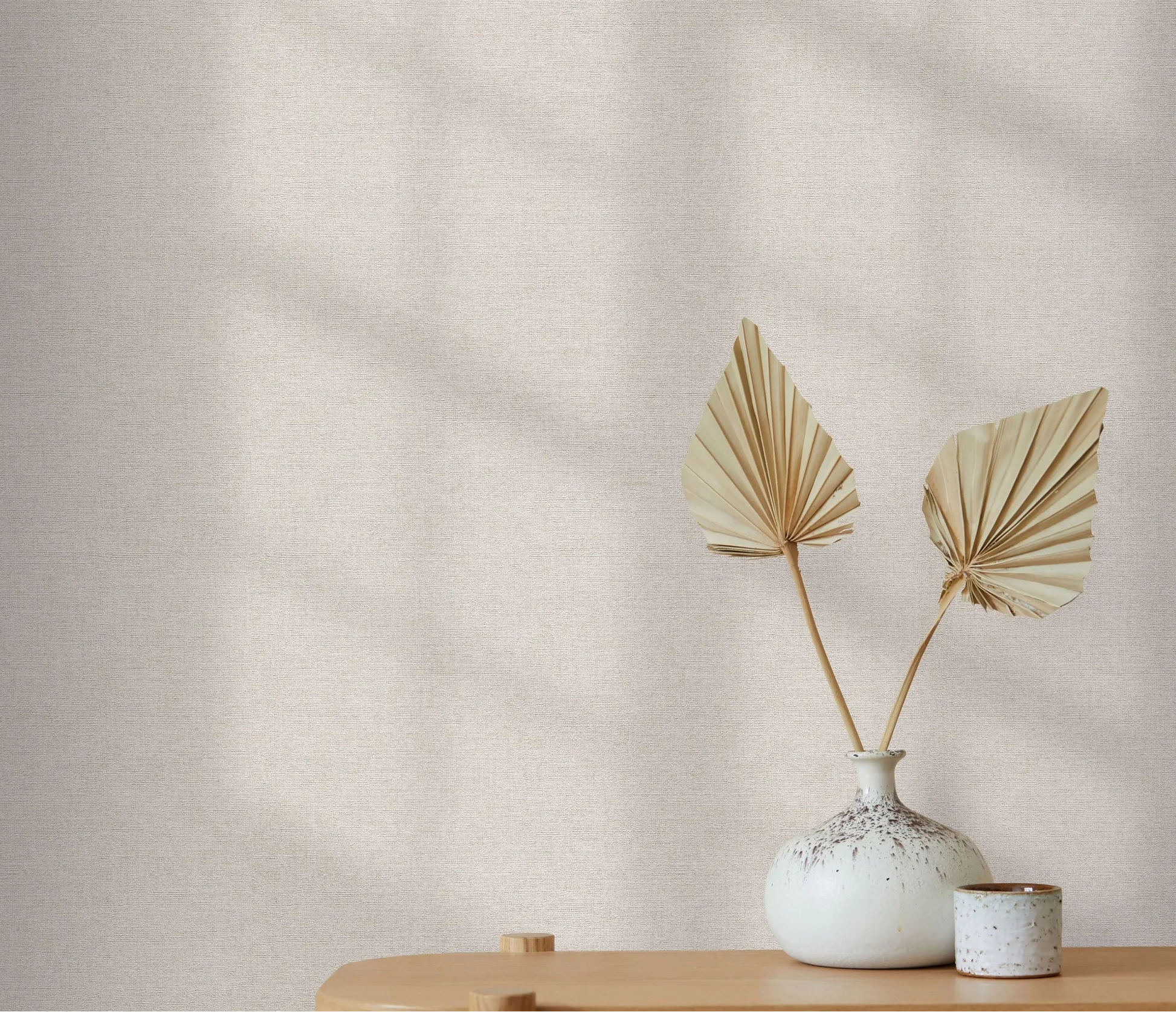 Erismann Forest Dreams 10563-38 wallpaper on a softly textured neutral wall behind a vase with dried palm leaves.