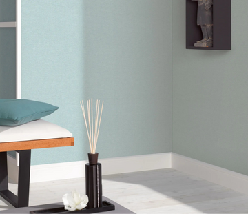 Erismann Forest Dreams 10563-43 wallpaper on a softly textured blue corner wall behind a bench with teal cushion.