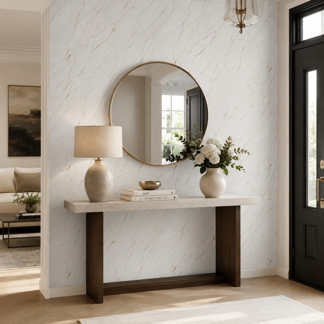 Erismann Opus 10440-31 white and gold marble-effect wallpaper in an elegant entryway with a round brass mirror, console table, black front door, soft florals, and warm neutral accents.