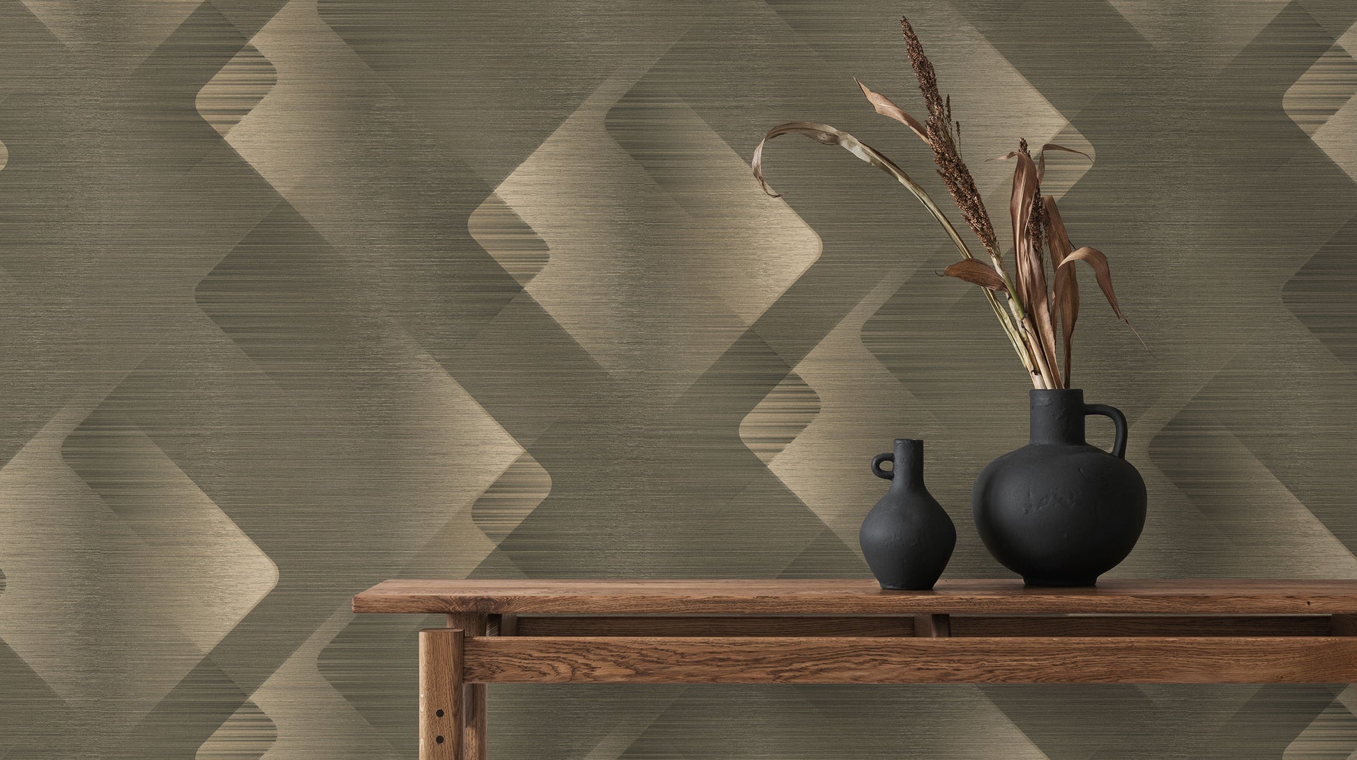 Erismann Elysium geometric wallpaper in olive green, beige, and taupe tones with layered diamond shapes and a subtle textured finish, styled with wooden furniture and dark decorative vases.