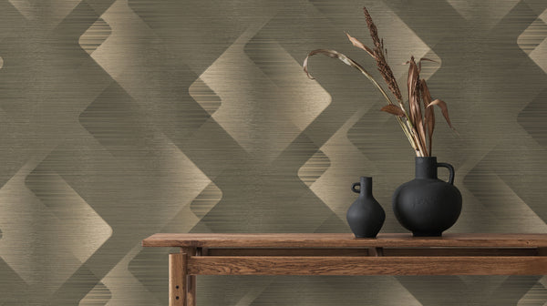 Erismann Elysium geometric wallpaper in olive green, beige, and taupe tones with layered diamond shapes and a subtle textured finish, styled with wooden furniture and dark decorative vases.