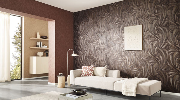 Erismann Elysium botanical feather wallpaper in deep espresso brown and metallic bronze tones, installed as a feature wall in a modern living room, adding depth and texture while complementing neutral furnishings and warm architectural accents.