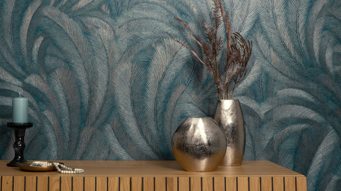 Erismann Elysium botanical wallpaper with layered feather-like leaves in rich teal and petrol tones, enhanced by fine linear texture and subtle metallic taupe accents for depth and movement.