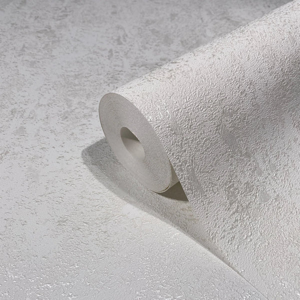 Marburg Avalon 31645 Close-up of a white textured wallpaper roll with an irregular plaster-like pattern, partially unrolled on a matching surface.