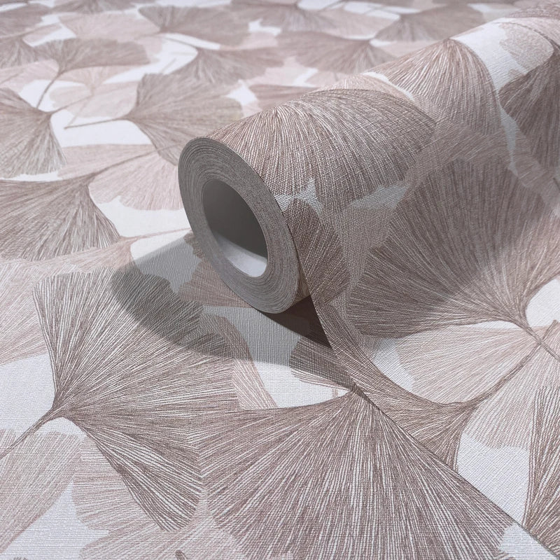 Marburg Boho 35780 Close-up of a beige and brown ginkgo leaf wallpaper with a roll resting on the matching surface.