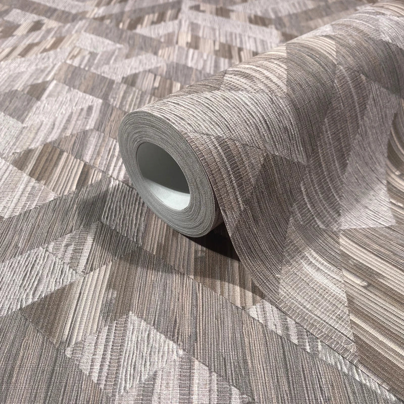 Marburg Boho 35791 A wallpaper roll resting on an unrolled sheet showing a brown and grey geometric pattern of angled blocks with fine linear striations; the roll core is visible.