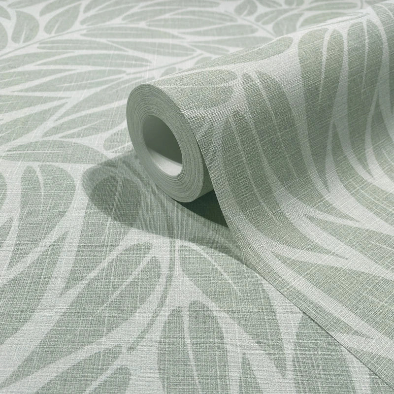 Marburg Boho 35793 Close-up of a wallpaper roll resting on the same pattern, showing a green and white large leaf design with a fine crosshatch texture.