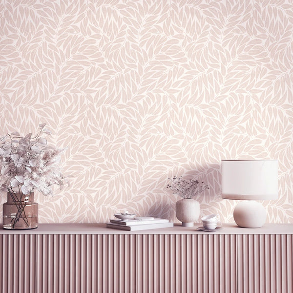 Marburg Boho 35795 Beige leaf-pattern wallpaper behind a ribbed sideboard with a table lamp, a glass vase with dried leaves, a small ceramic vase with stems, stacked books, and small bowls.