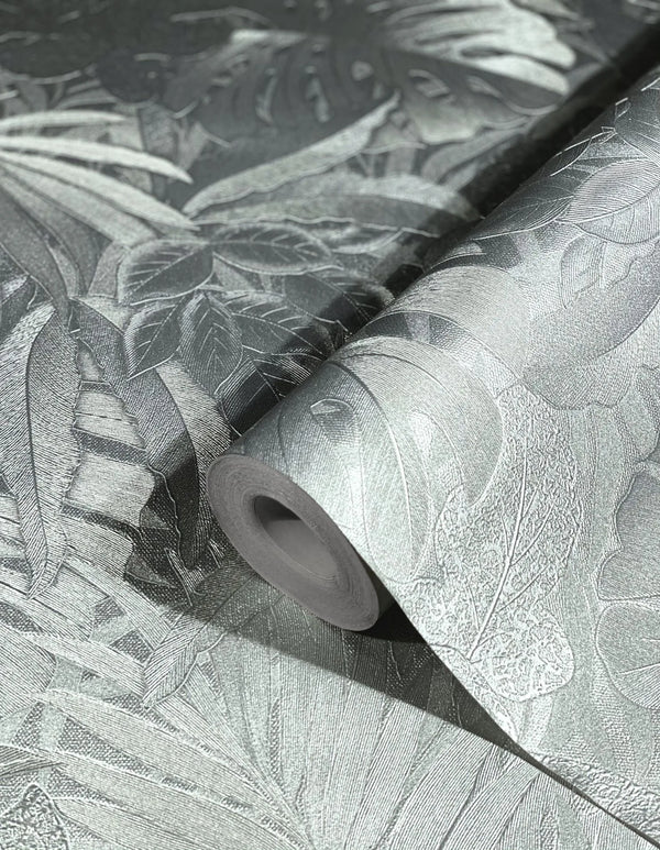 Marburg Botanica 33301 Close-up of a silver metallic botanical wallpaper roll on a matching unrolled sheet, showing embossed tropical leaf textures.