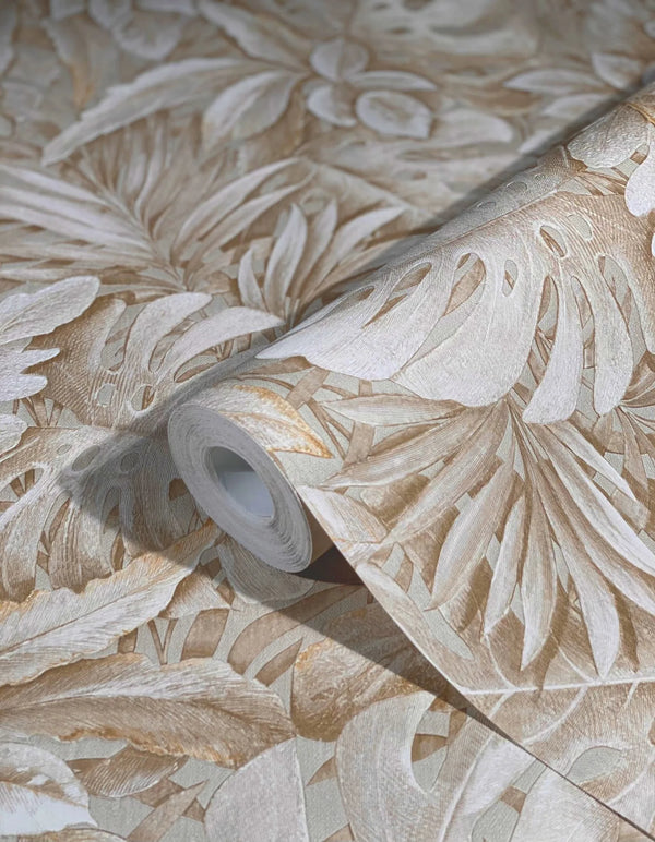 Marburg Botanica 33307 Close-up of a wallpaper roll with a beige tropical leaf pattern resting on matching unrolled wallpaper.