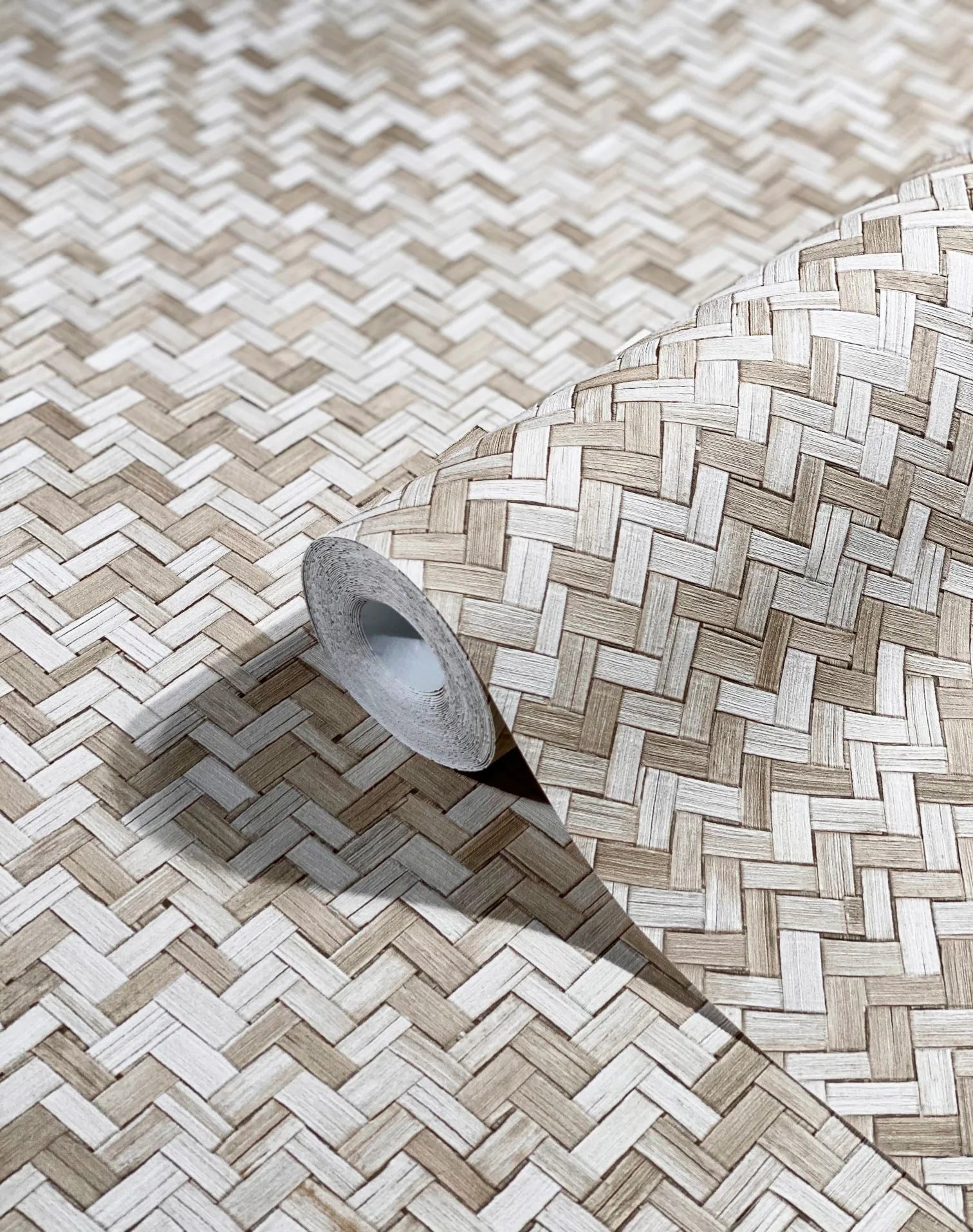 Marburg Botanica 33309 Close-up of a wallpaper roll resting on matching wallpaper showing a beige and white herringbone basket-weave pattern.