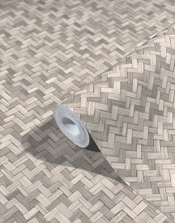 Marburg Botanica 33311 Roll of wallpaper unrolled across a surface showing a beige and gray basketweave pattern with woodgrain-like texture; inner core and shadow visible.