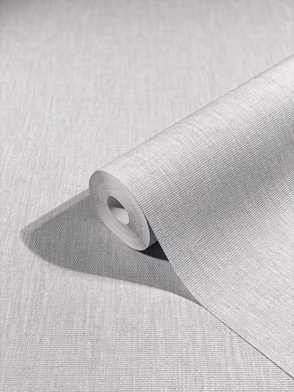 Marburg Botanica 33324 A light gray textured wallpaper roll partially unrolled on a matching surface, showing a fine woven linen-like pattern.