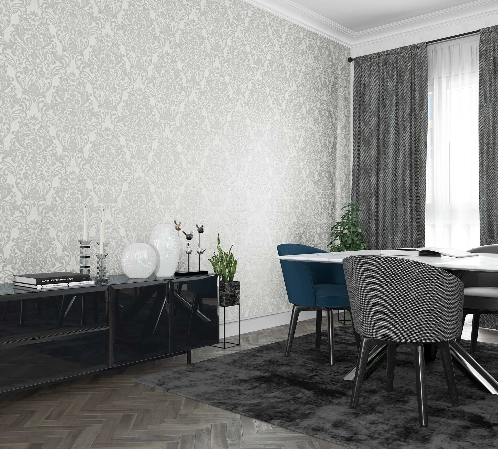 Marburg City Glam 32602 Room scene with a white wall covered in light gray damask wallpaper behind a dining table with blue and gray chairs, a black sideboard with decor, a window with gray curtains, a rug, and indoor plants.