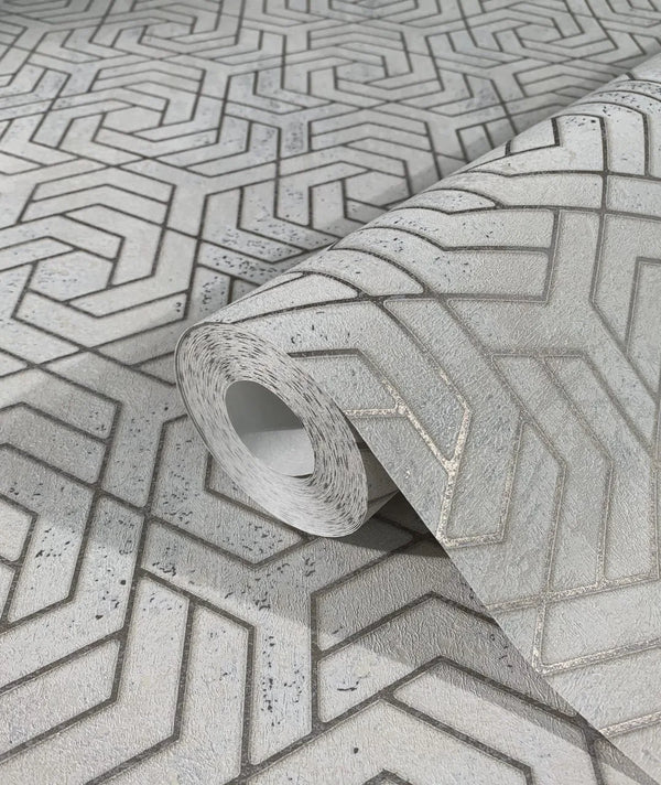 Marburg City Glam 32608 Close-up of a gray geometric wallpaper roll resting on the same pattern, showing interlocking chevron lines on a textured background.