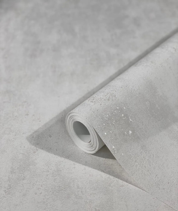 Marburg City Glam 32611 Angled roll of light gray textured wallpaper resting on a matching unrolled sheet, showing a subtle mottled pattern with fine speckling.