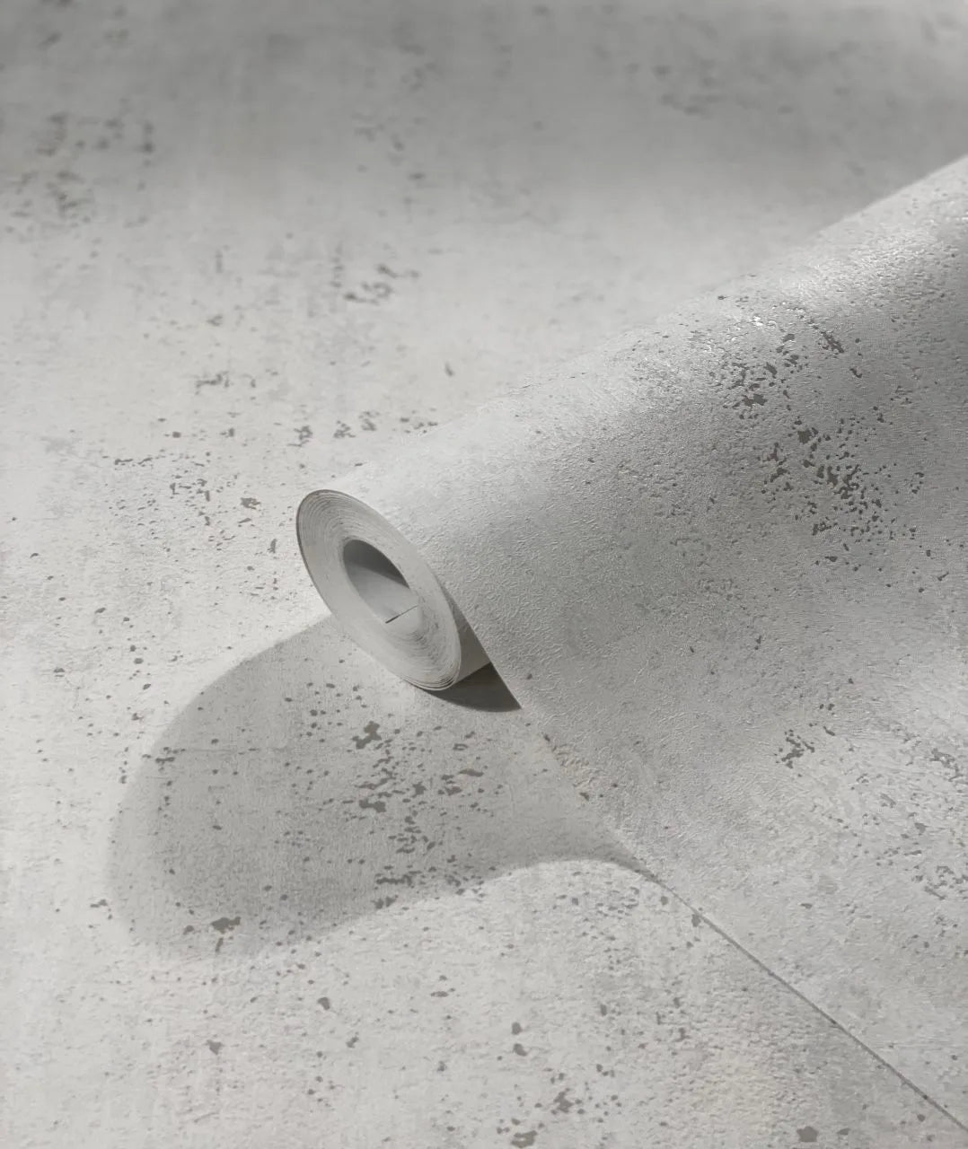 Marburg City Glam 32612 A light gray speckled wallpaper roll partially unrolled on matching material, showing the textured pattern up close.