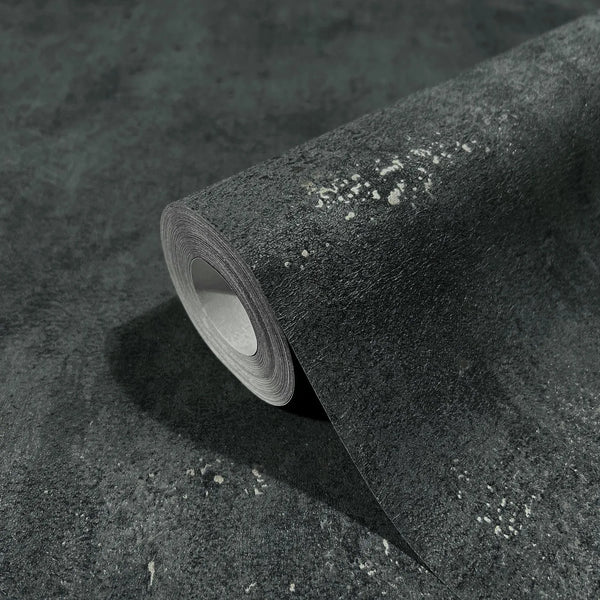 Marburg City Glam 32638 A dark mottled wallpaper roll with scattered light speckles, shown resting on a matching unrolled sheet.