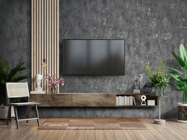 Marburg City Glam 32638 Charcoal gray wallpaper with a mottled, concrete-like texture and irregular light speckles wallpaper on a living room feature wall.