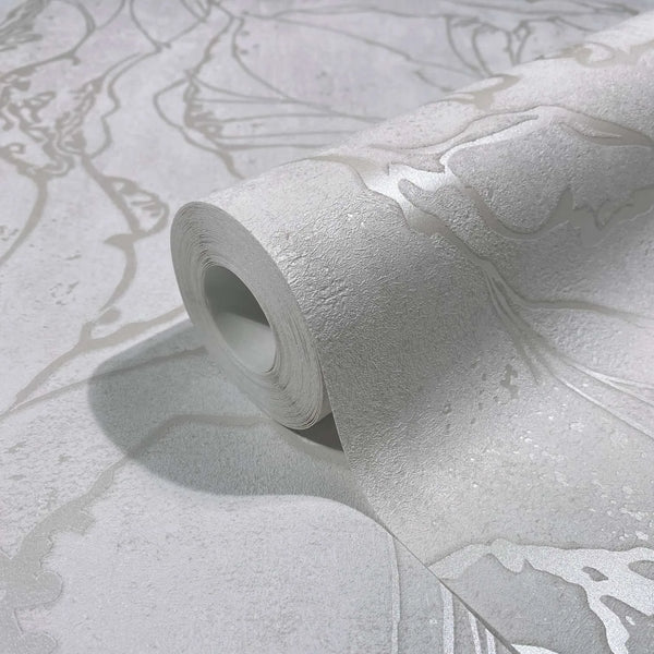 Marburg City Glow 34251 Close-up of a white textured wallpaper roll with metallic abstract line pattern, partially unrolled on the matching surface.