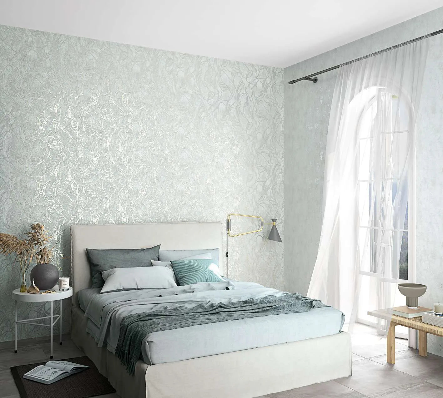 Marburg City Glow 34253 Bedroom scene with a light gray wallpaper featuring an organic swirling pattern on the wall behind an upholstered bed, next to sheer curtains over an arched window.
