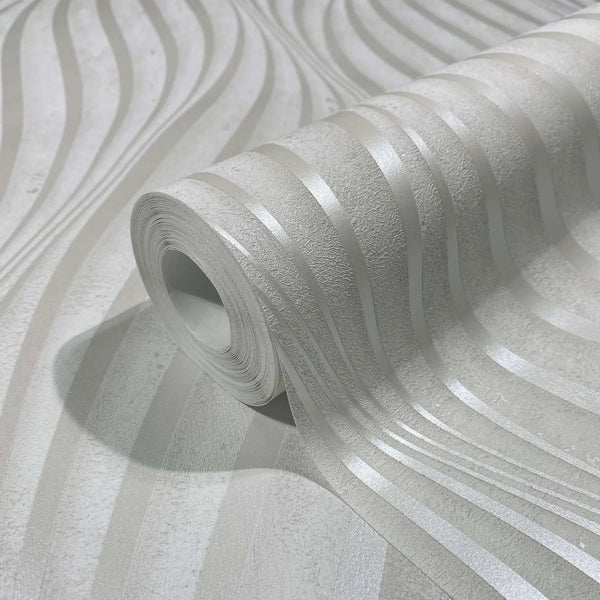 Marburg City Glow 34258 Close-up of a wallpaper roll on a matching sheet, showing light-toned wavy stripes with a subtle sheen and a softly textured background.