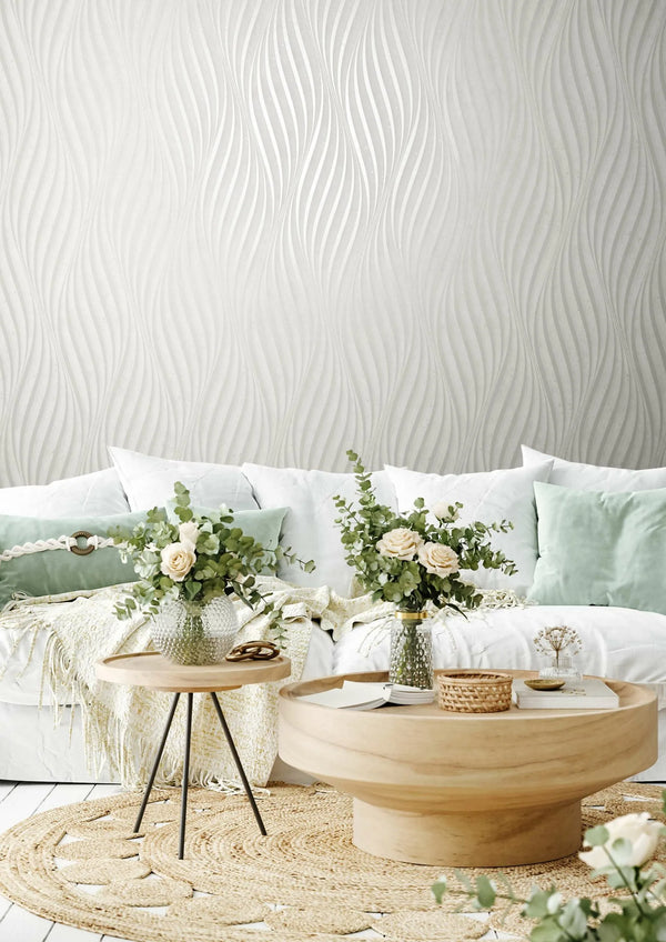 Marburg City Glow 34258 Light neutral wallpaper with a flowing vertical wave motif in a tone-on-tone look, creating a soft, wallpaper on a living room feature wall.