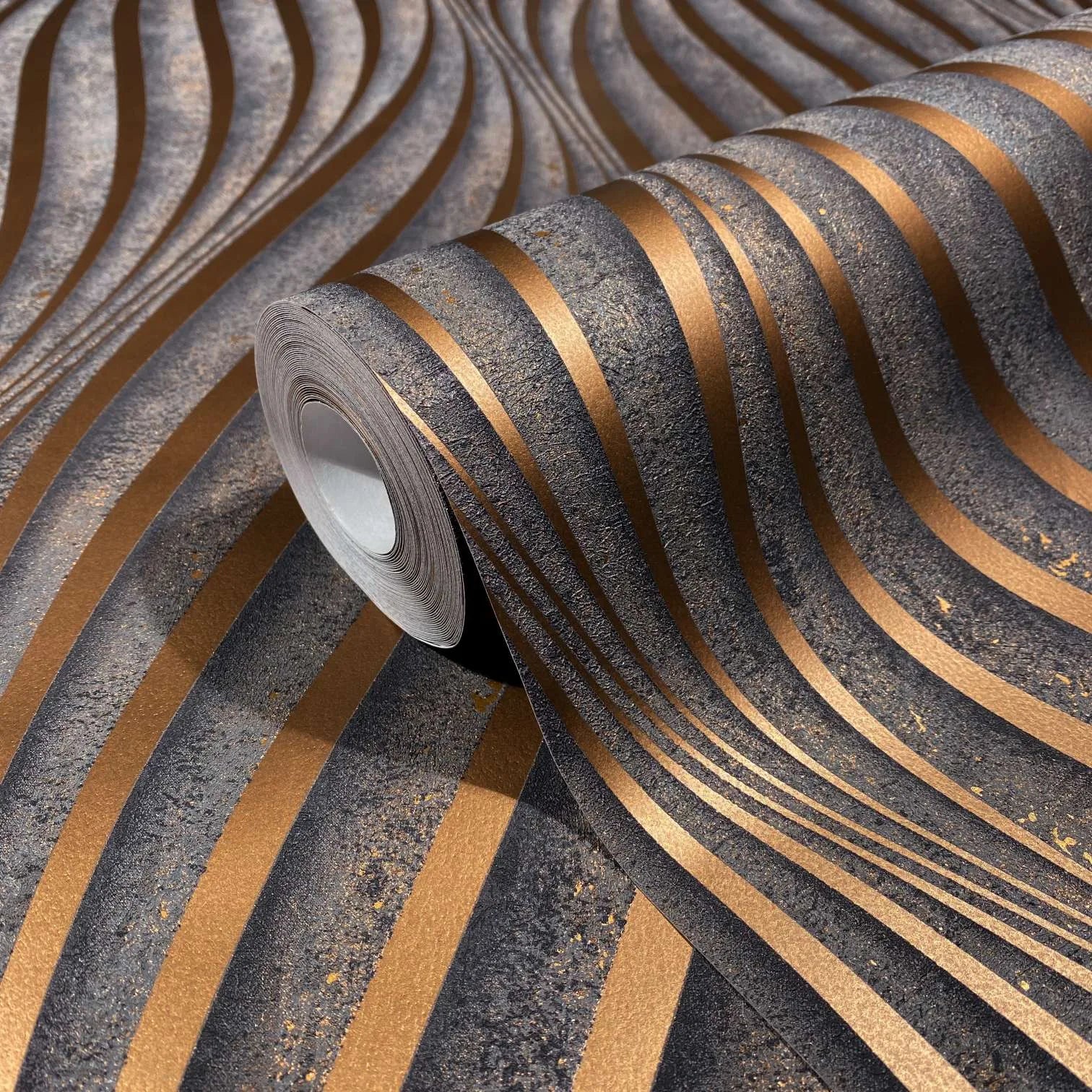 Marburg City Glow 34263 Wallpaper roll on matching surface showing wavy copper stripes across a dark textured background with speckled detail.